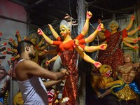 An artisan decorates the idol of the Hindu Goddess Durga ahead of the Durga Puja festival in Nagaon District, Assam, India, on October 3, 20...