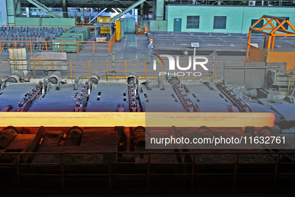 Workers perform a routine inspection at a hot rolling workshop of Lubao Steel Pipe Co., LTD in the Fushan district of Yantai, China, on Octo...