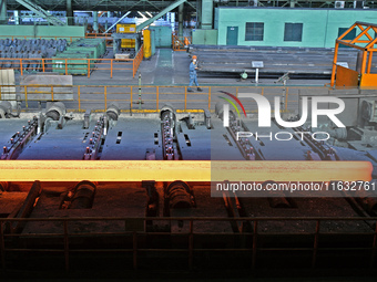 Workers perform a routine inspection at a hot rolling workshop of Lubao Steel Pipe Co., LTD in the Fushan district of Yantai, China, on Octo...