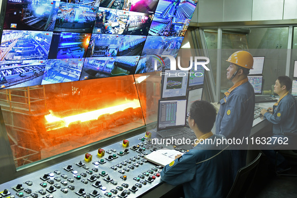 Workers monitor the operation of a system in a hot rolling operation room at Lubao Steel Pipe Co LTD in the Fushan district of Yantai, China...