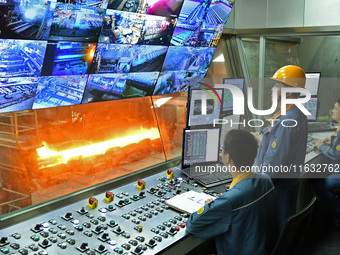 Workers monitor the operation of a system in a hot rolling operation room at Lubao Steel Pipe Co LTD in the Fushan district of Yantai, China...