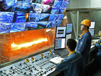 Workers monitor the operation of a system in a hot rolling operation room at Lubao Steel Pipe Co LTD in the Fushan district of Yantai, China...