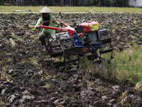 A farmer breaks up the soil with a tractor in a rice field in Triyagen Village, Mojolaban, Sukoharjo City, Central Java, on October 3, 2024...