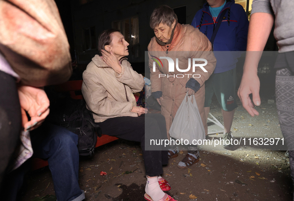 Local residents are seen outside the apartment building damaged by a Russian guided missile strike in Kharkiv, Ukraine, on September 3, 2024...