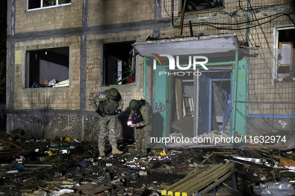 Servicemen are seen outside a residential building damaged by a Russian guided missile strike in Kharkiv, Ukraine, on September 3, 2024. 