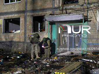 Servicemen are seen outside a residential building damaged by a Russian guided missile strike in Kharkiv, Ukraine, on September 3, 2024. (