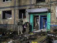 Servicemen are seen outside a residential building damaged by a Russian guided missile strike in Kharkiv, Ukraine, on September 3, 2024. (