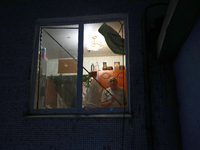 A man is seen through the window of the residential building damaged by a Russian guided missile strike in Kharkiv, Ukraine, on September 3,...