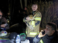 A rescuer holds a cat outside the residential building damaged by a Russian guided missile strike in Kharkiv, Ukraine, on September 3, 2024....