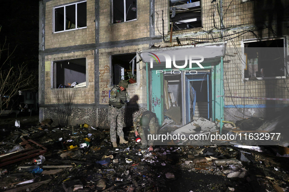 Servicemen are seen outside a residential building damaged by a Russian guided missile strike in Kharkiv, Ukraine, on September 3, 2024. 