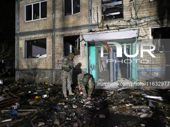 Servicemen are seen outside a residential building damaged by a Russian guided missile strike in Kharkiv, Ukraine, on September 3, 2024. (