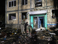 Servicemen are seen outside a residential building damaged by a Russian guided missile strike in Kharkiv, Ukraine, on September 3, 2024. (