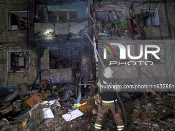 A firefighter puts out a fire in a residential building damaged by a Russian guided missile strike in Kharkiv, Ukraine, on September 3, 2024...