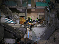 Rescuers are seen in a residential building damaged by a Russian guided missile strike in Kharkiv, Ukraine, on September 3, 2024. NO USE RUS...