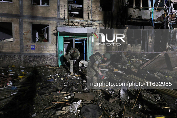 Servicemen are seen outside a residential building damaged by a Russian guided missile strike in Kharkiv, Ukraine, on September 3, 2024. 