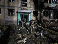 Servicemen are seen outside a residential building damaged by a Russian guided missile strike in Kharkiv, Ukraine, on September 3, 2024. (