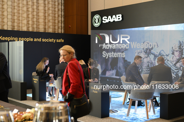 People sit at the SAAB AB lounge during the Warsaw Security Forum 2024 in Warsaw, Poland on October 2, 2024. WSF2024, entitled 'Ensuring Sec...