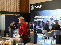 People sit at the SAAB AB lounge during the Warsaw Security Forum 2024 in Warsaw, Poland on October 2, 2024. WSF2024, entitled 'Ensuring Sec...