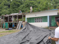 Villagers living in Laltong Village colony, approximately 20 km from Siliguri, carry their household items to a safer place on October 3, 20...