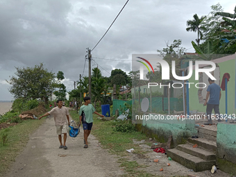 Villagers living in Laltong Village colony, approximately 20 km from Siliguri, carry their household items to a safer place on October 3, 20...