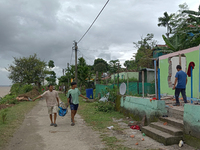 Villagers living in Laltong Village colony, approximately 20 km from Siliguri, carry their household items to a safer place on October 3, 20...