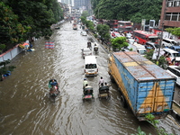 Vehicles and rickshaws try to drive with passengers through the waterlogged streets of Dhaka, Bangladesh, on October 3, 2024, after heavy mo...