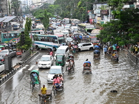 Vehicles and rickshaws try to drive with passengers through the waterlogged streets of Dhaka, Bangladesh, on October 3, 2024, after heavy mo...