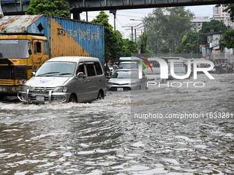 Vehicles and rickshaws try to drive with passengers through the waterlogged streets of Dhaka, Bangladesh, on October 3, 2024, after heavy mo...