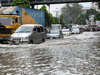 Vehicles and rickshaws try to drive with passengers through the waterlogged streets of Dhaka, Bangladesh, on October 3, 2024, after heavy mo...