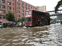 Vehicles and rickshaws try to drive with passengers through the waterlogged streets of Dhaka, Bangladesh, on October 3, 2024, after heavy mo...