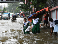 Vehicles and rickshaws try to drive with passengers through the waterlogged streets of Dhaka, Bangladesh, on October 3, 2024, after heavy mo...