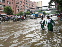 Vehicles and rickshaws try to drive with passengers through the waterlogged streets of Dhaka, Bangladesh, on October 3, 2024, after heavy mo...