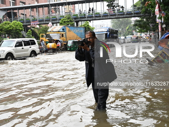 Vehicles and rickshaws try to drive with passengers through the waterlogged streets of Dhaka, Bangladesh, on October 3, 2024, after heavy mo...