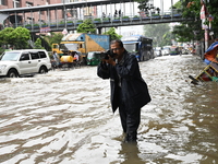 Vehicles and rickshaws try to drive with passengers through the waterlogged streets of Dhaka, Bangladesh, on October 3, 2024, after heavy mo...