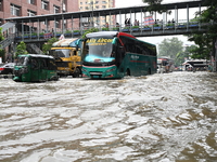 Vehicles and rickshaws try to drive with passengers through the waterlogged streets of Dhaka, Bangladesh, on October 3, 2024, after heavy mo...