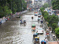 Vehicles and rickshaws try to drive with passengers through the waterlogged streets of Dhaka, Bangladesh, on October 3, 2024, after heavy mo...