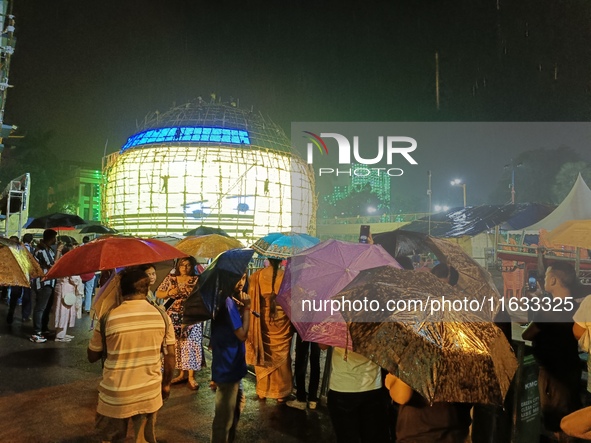 Visitor's Hold Umbrella Amid Heavy Rain And Visiting A Puja Pandal Ahead The Durga Puja Festival In Kolkata, India On October 3,2024.