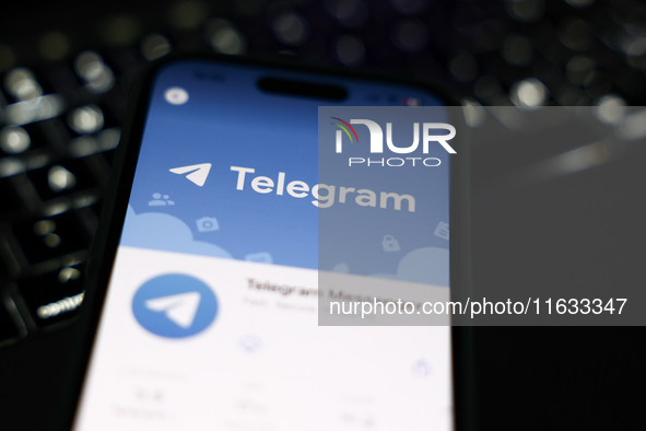 A laptop keyboard and Telegram on App Store displayed on a phone screen are seen in this illustration photo taken in Krakow, Poland on Octob...