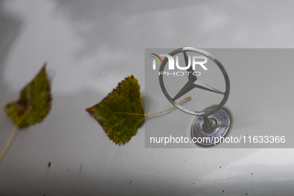 Leaves and Mercedes-Benz logo are seen on a car in Krakow, Poland on October 2, 2024. 