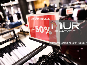 Mid season sale sign is seen in a clothing store in Krakow, Poland on October 2, 2024. (