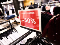 Mid season sale sign is seen in a clothing store in Krakow, Poland on October 2, 2024. (