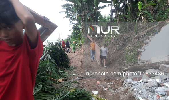 Villagers living in Laltong Village colony, approximately 20 km from Siliguri, carry their household items to a safer place in Laltong Villa...