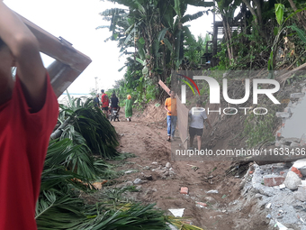 Villagers living in Laltong Village colony, approximately 20 km from Siliguri, carry their household items to a safer place in Laltong Villa...