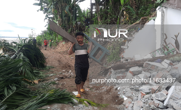 Villagers living in Laltong Village colony, approximately 20 km from Siliguri, carry their household items to a safer place in Laltong Villa...