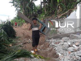 Villagers living in Laltong Village colony, approximately 20 km from Siliguri, carry their household items to a safer place in Laltong Villa...