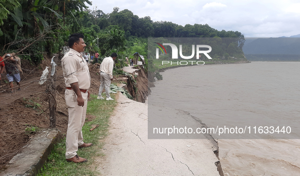 Villagers living in Laltong Village colony, approximately 20 km from Siliguri, carry their household items to a safer place in Laltong Villa...