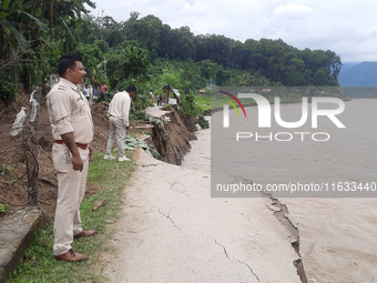 Villagers living in Laltong Village colony, approximately 20 km from Siliguri, carry their household items to a safer place in Laltong Villa...