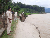 Villagers living in Laltong Village colony, approximately 20 km from Siliguri, carry their household items to a safer place in Laltong Villa...