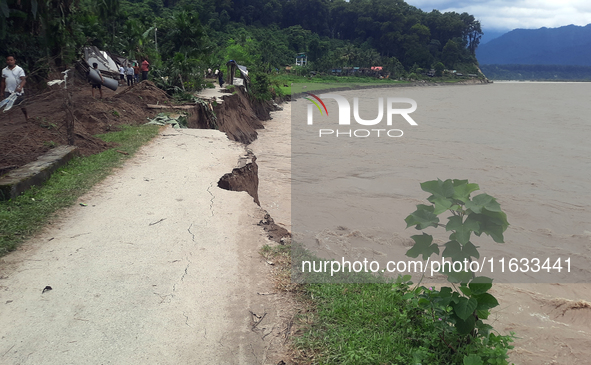 Villagers living in Laltong Village colony, approximately 20 km from Siliguri, carry their household items to a safer place in Laltong Villa...