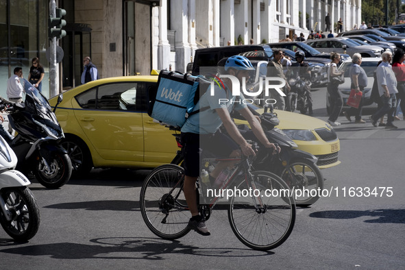 A Wolt delivery person rides a bicycle in the center of Athens, Greece, on October 3, 2024. Wolt is the second most popular delivery company...